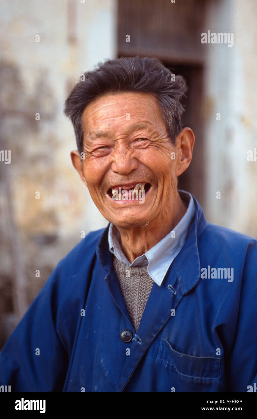 Vieil homme à travers et dents manquantes au 11ème siècle village de Xidi, Anhui Province, China Banque D'Images