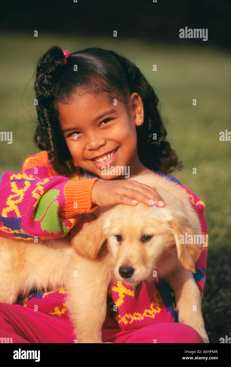 Close up libre diversité diversité douce jeune fille 7-9 ans ans holding puppy smiling portrait MR © Myrleen Pearson Banque D'Images