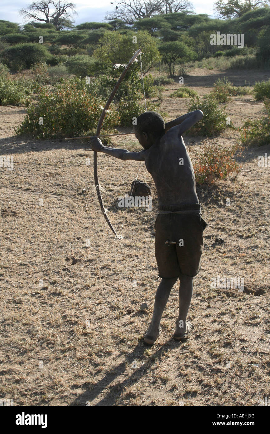 Jeune garçon chasseur de chasseurs-cueilleurs tribu Hadza oiseaux de chasse à l'arc et la flèche près du lac Eyasi en Tanzanie Afrique de l'Est Banque D'Images