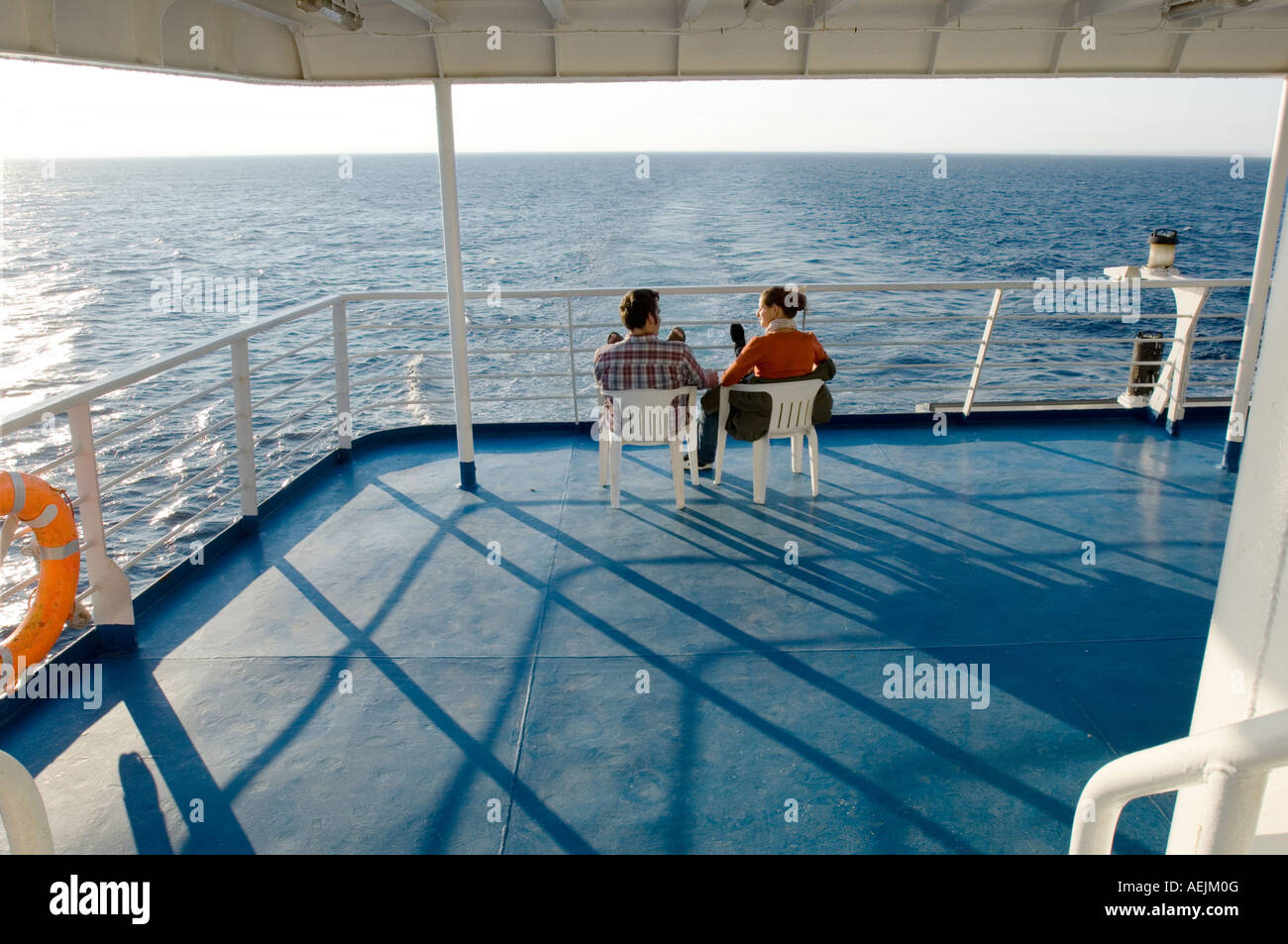 Voyage en mer. Un couple est assis sur le pont d'un ferry et donnent sur la mer. Mediterranien Mer, la Grèce. Banque D'Images