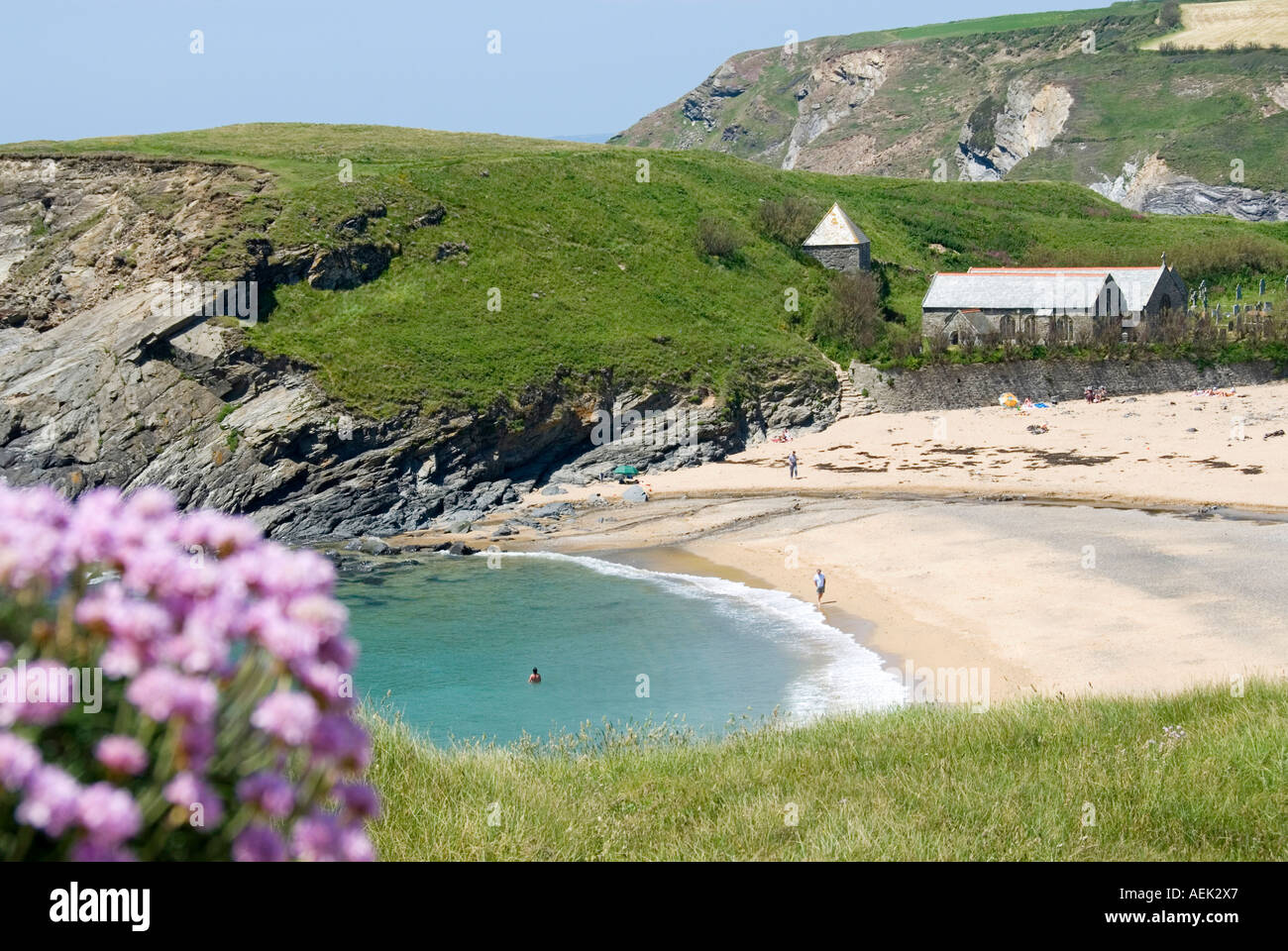 Paysage de Cornouailles peu de personnes sur la plage de sable à Church Cove Gunwalloe et Parish Church of Saint Winwaloe un ancien grade I classé bâtiment Angleterre Royaume-Uni Banque D'Images