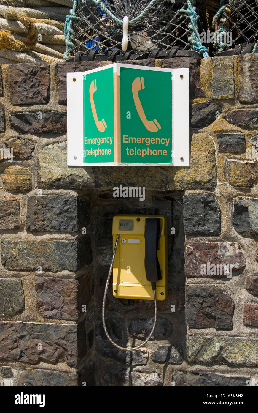 Mullion Cove port archive historique année 2006 mur de pierre emplacement pour une installation téléphonique d'urgence avec des panneaux verts en Cornwall Angleterre Royaume-Uni Banque D'Images