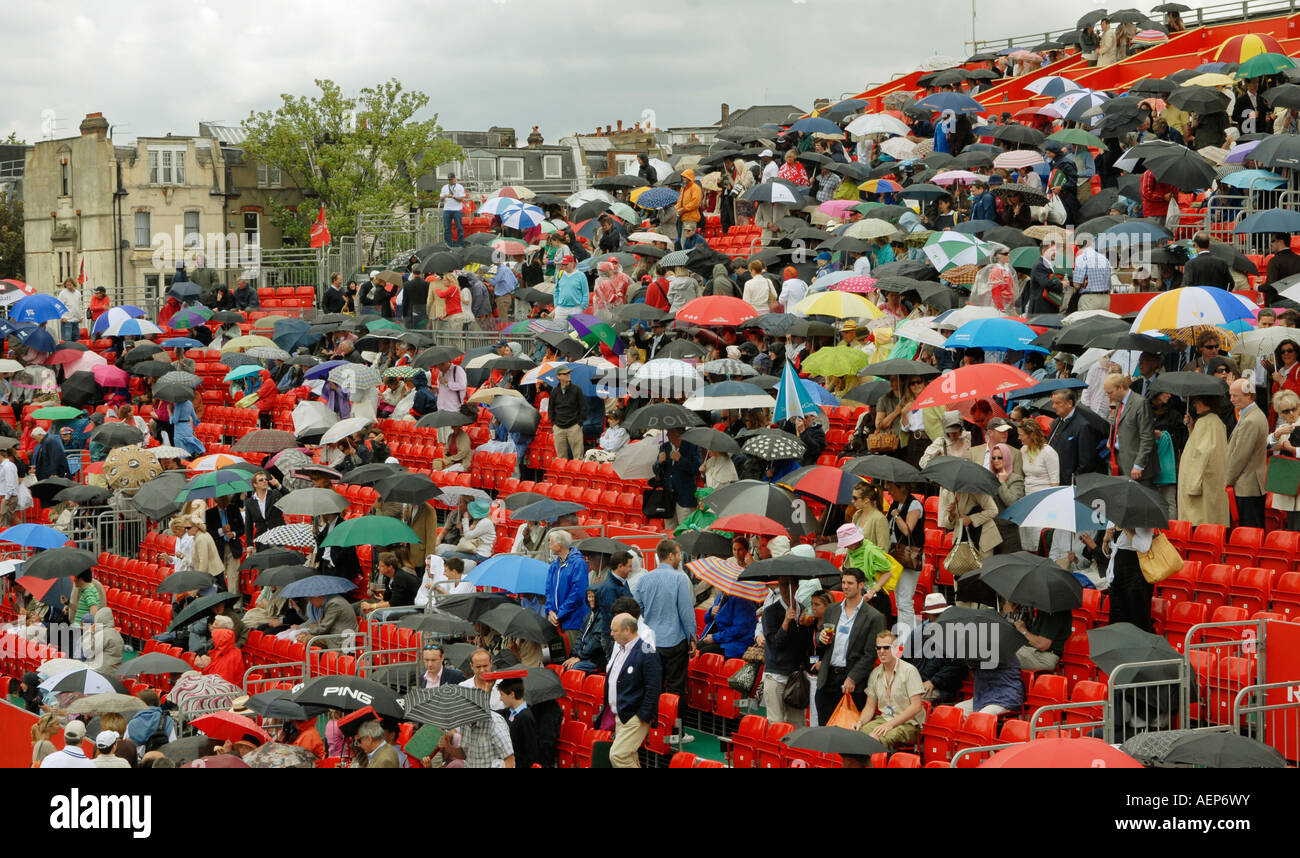 Spectateurs mis en place leur parapluie en pluie interupts jouer au tournoi de tennis de l'Artois à Queen's à Londres, en Angleterre Banque D'Images