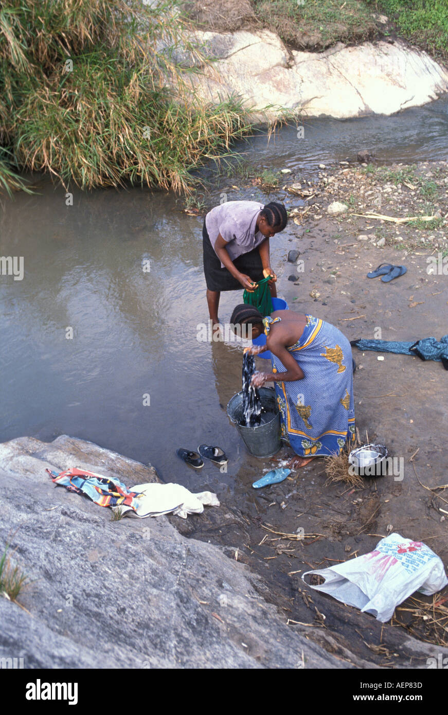 Les femmes lavent les vêtements dans une rivière dans le district de Mgeta en Tanzanie. Banque D'Images