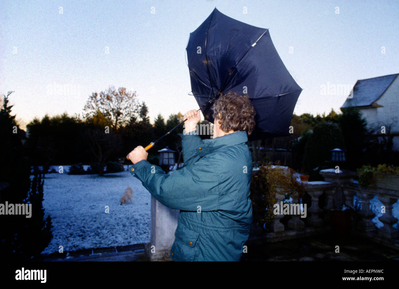 Homme avec parapluie souffler à l'intérieur dehors sur Jour de vent Banque D'Images