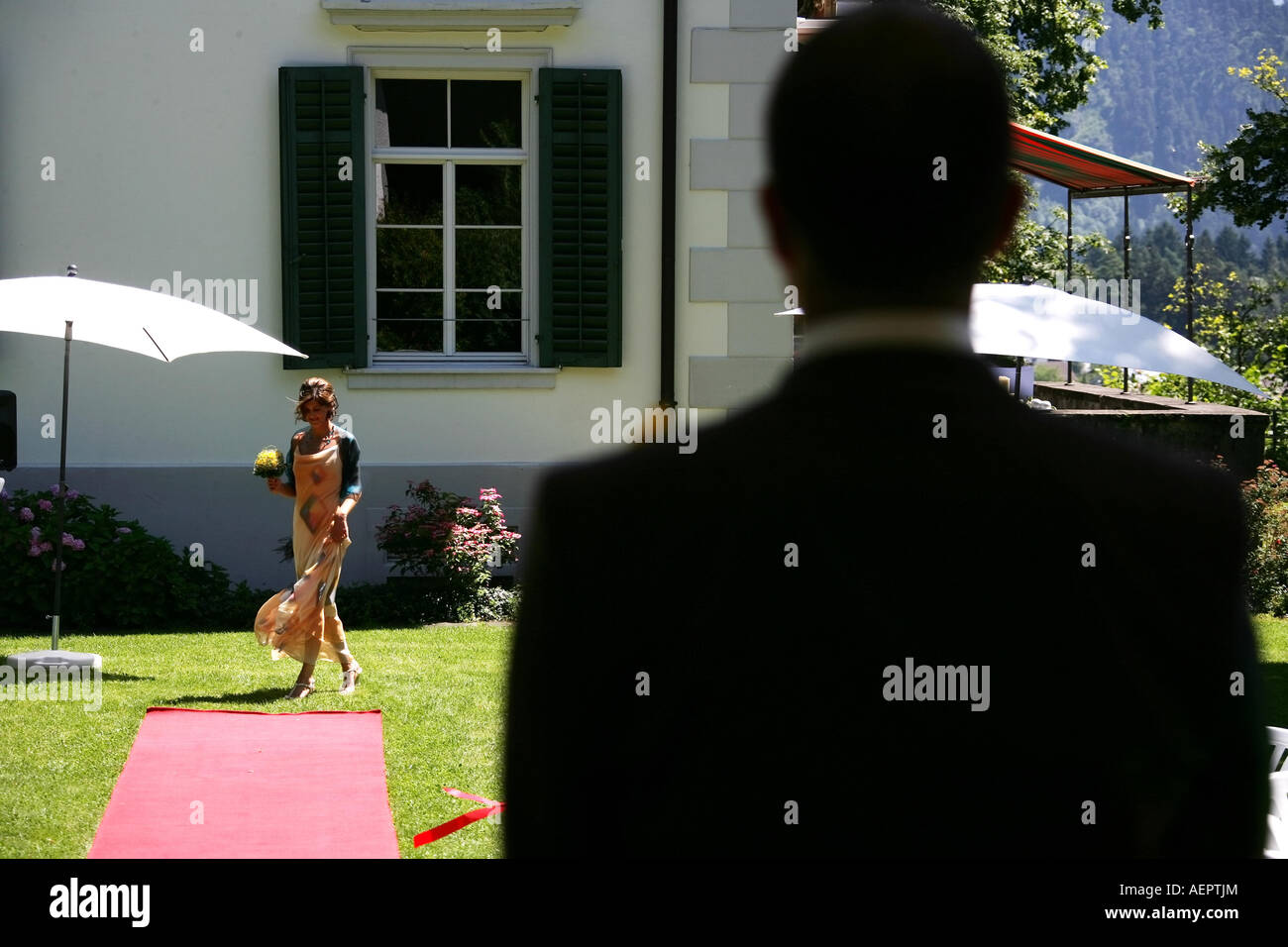 Un homme est en attente de sa mariée pour le mariage, elle marche le long d'un tapis rouge Banque D'Images