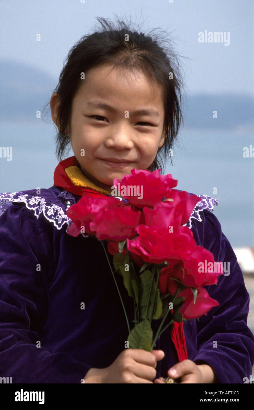 Chine,Chinois,Asie,Asiatiques asiatiques,extrême Orient,Orient,Orient,Orient,Orient,communisme,communiste,Xiamen,fille asiatique,filles,enfant,sourire,heureux,roses,salue navire de croisière passe Banque D'Images