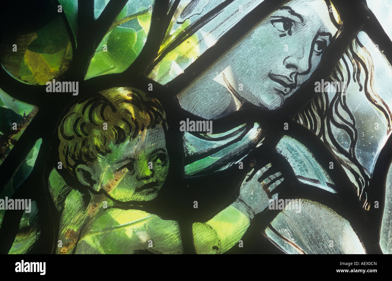 Détail de 1930 de l'église vitraux fenêtre avec ivy rétroéclairé contre elle de plus en plus moderne avec une Vierge Marie portant l'enfant Jésus Banque D'Images