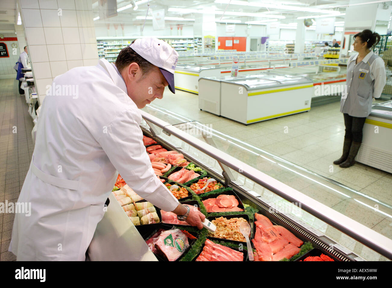 Le contrôle de la qualité des aliments lors de la mesure de température dans un boucher s shop dans un supermarché Banque D'Images