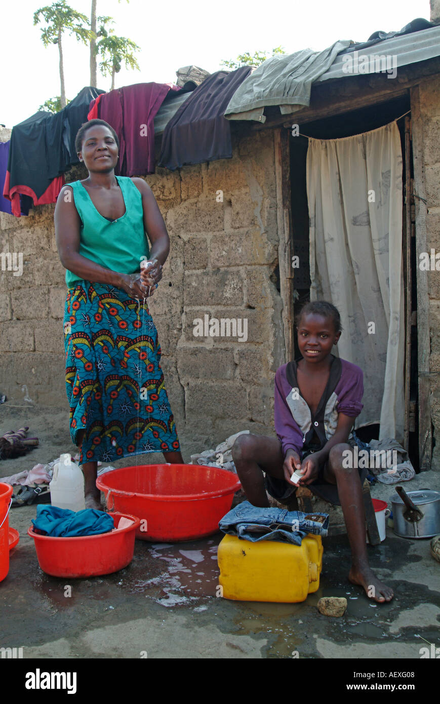 Mère et fille faire la lessive à l'extérieur de leur maison à Lusaka. La Zambie, l'Afrique Banque D'Images