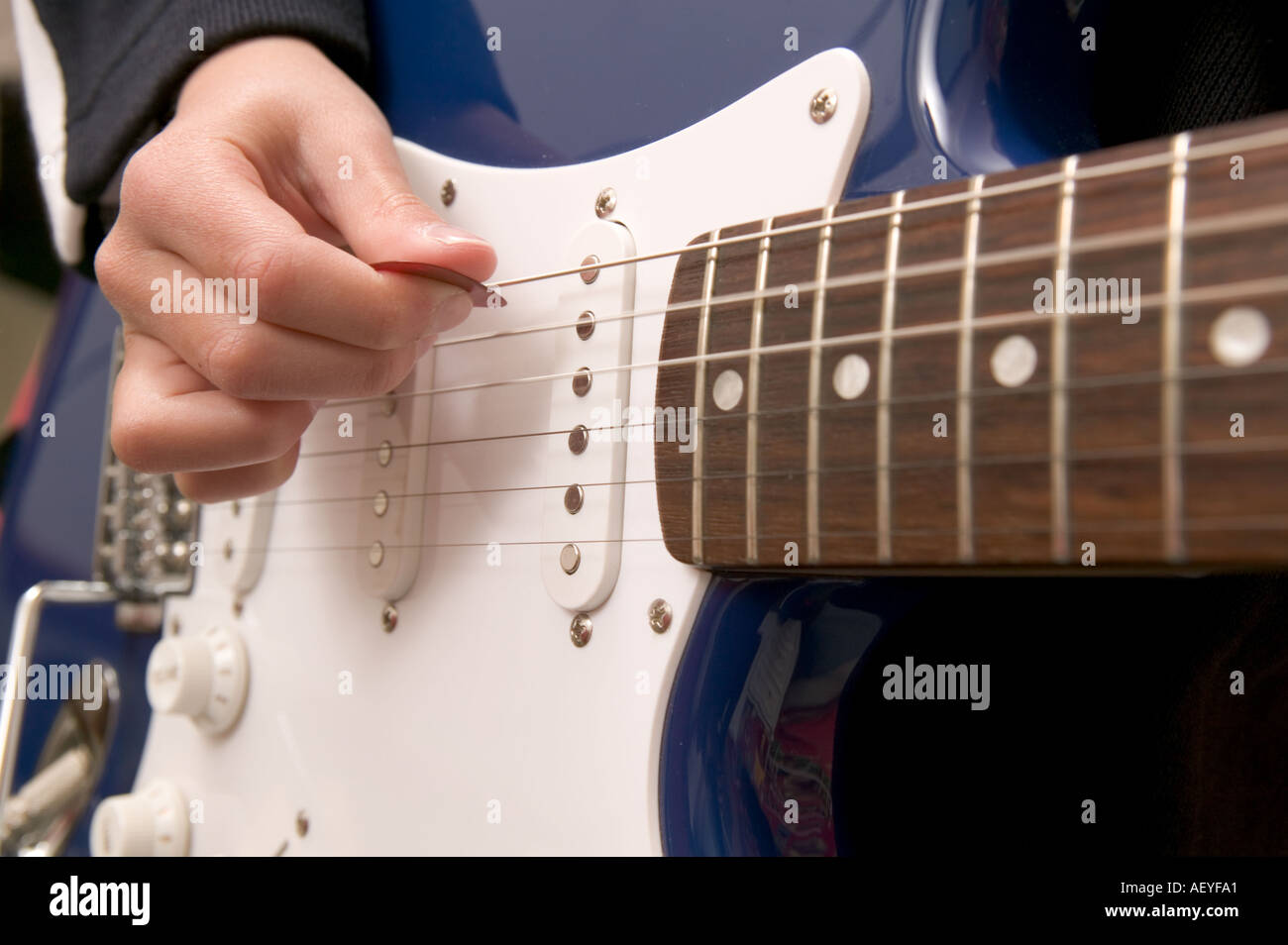 Close up of Boy à jouer de la guitare dans sa chambre à coucher Banque D'Images