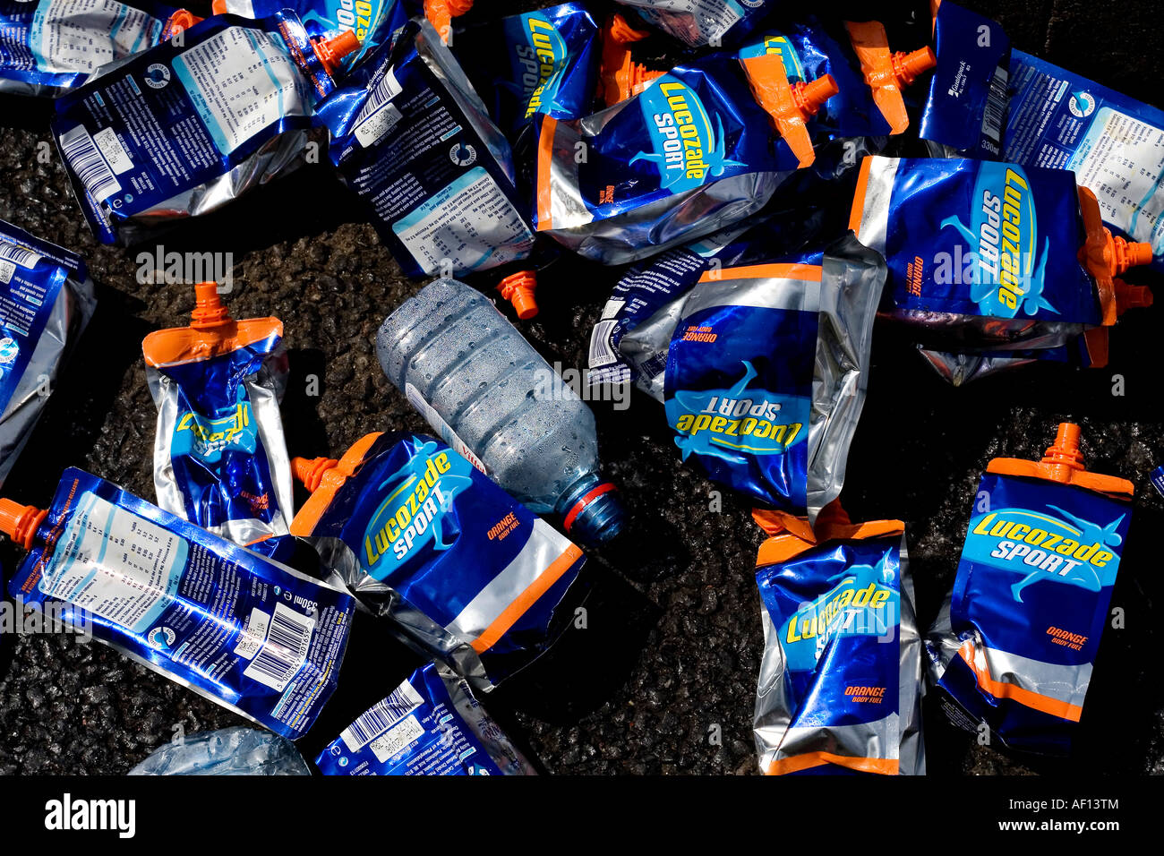 Lucozade sachets et bouteilles d'eau à gauche sur la route pendant le marathon de Londres. Banque D'Images