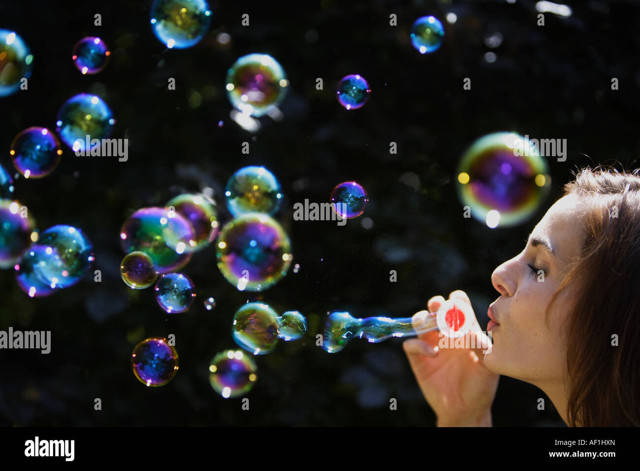 Femme avec des bulles de savon, Junge Frau blaest Seifenblasen dans die Luft Banque D'Images