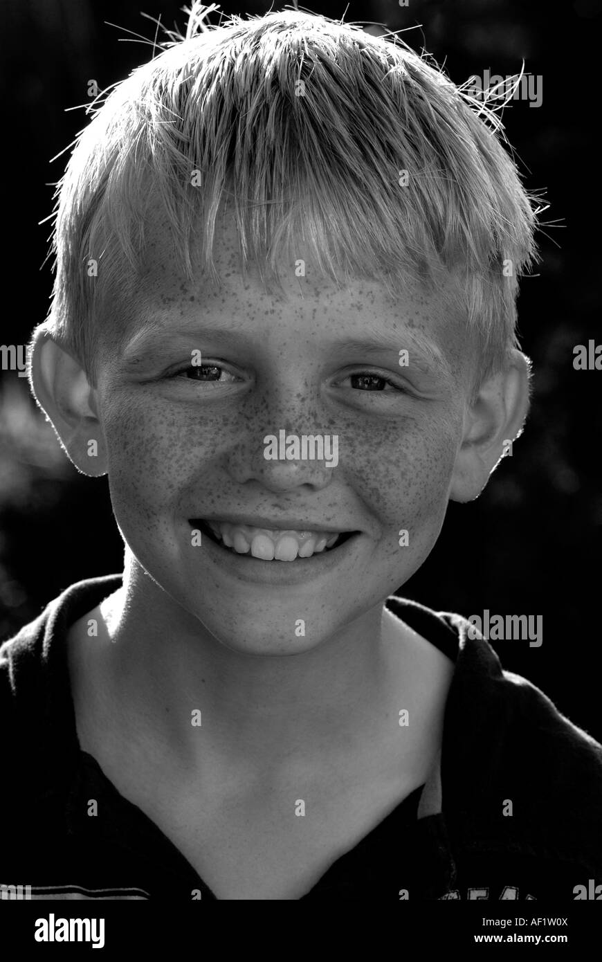 Portrait noir et blanc d'un jeune garçon aux cheveux blonds et aux taches de rousseur Banque D'Images