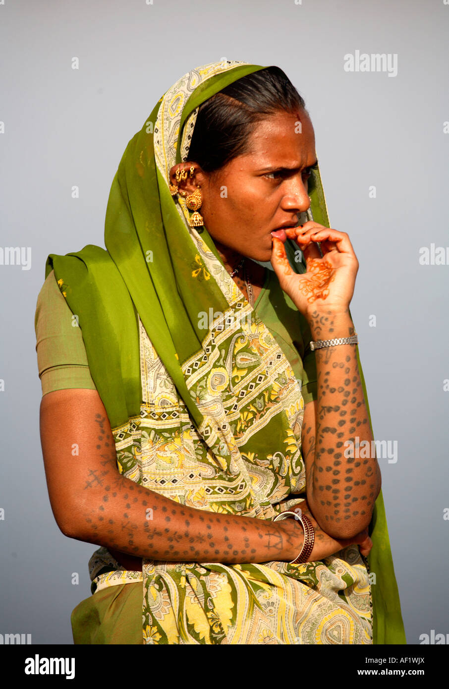 Pêcheur tribal pensif avec des oreilles couvertes d'or et des armes couvertes de tatouages au village de pêche de Vanakbara, île DIU, Gujarat, Inde Banque D'Images