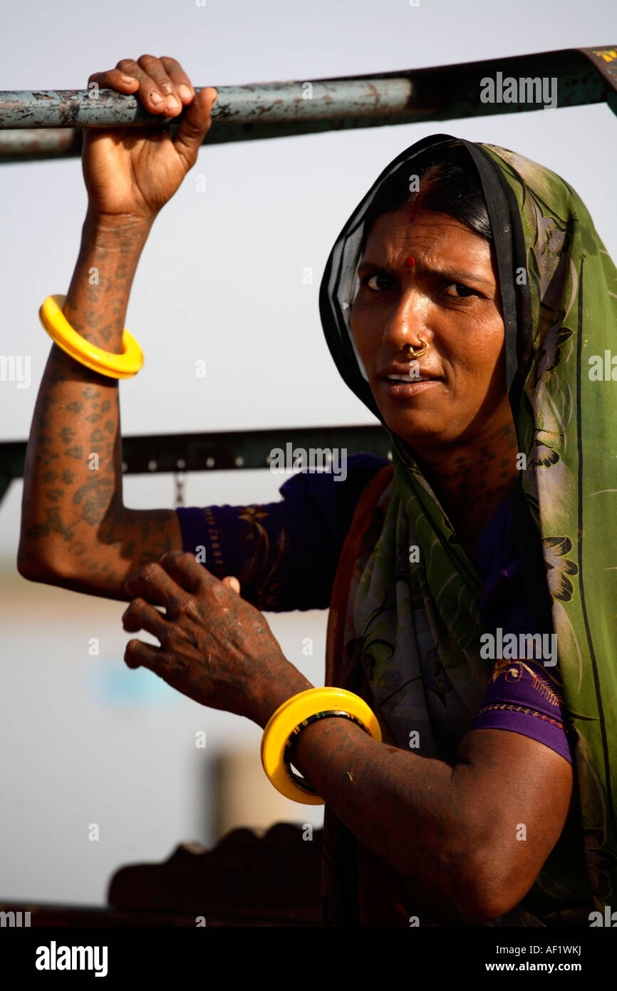 Femme tribale indienne aux armes tatouées à l'arrière du chakda quittant le village de pêche de Vanakbara, île DIU, Gujarat, Inde Banque D'Images
