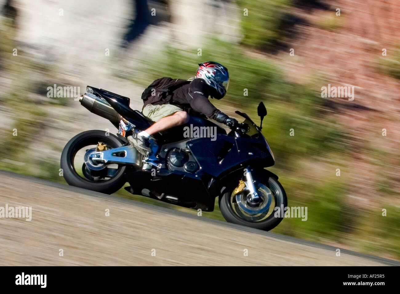 Bullet sport bike rider en short avec un sac à dos sur les coins dans un canyon Banque D'Images