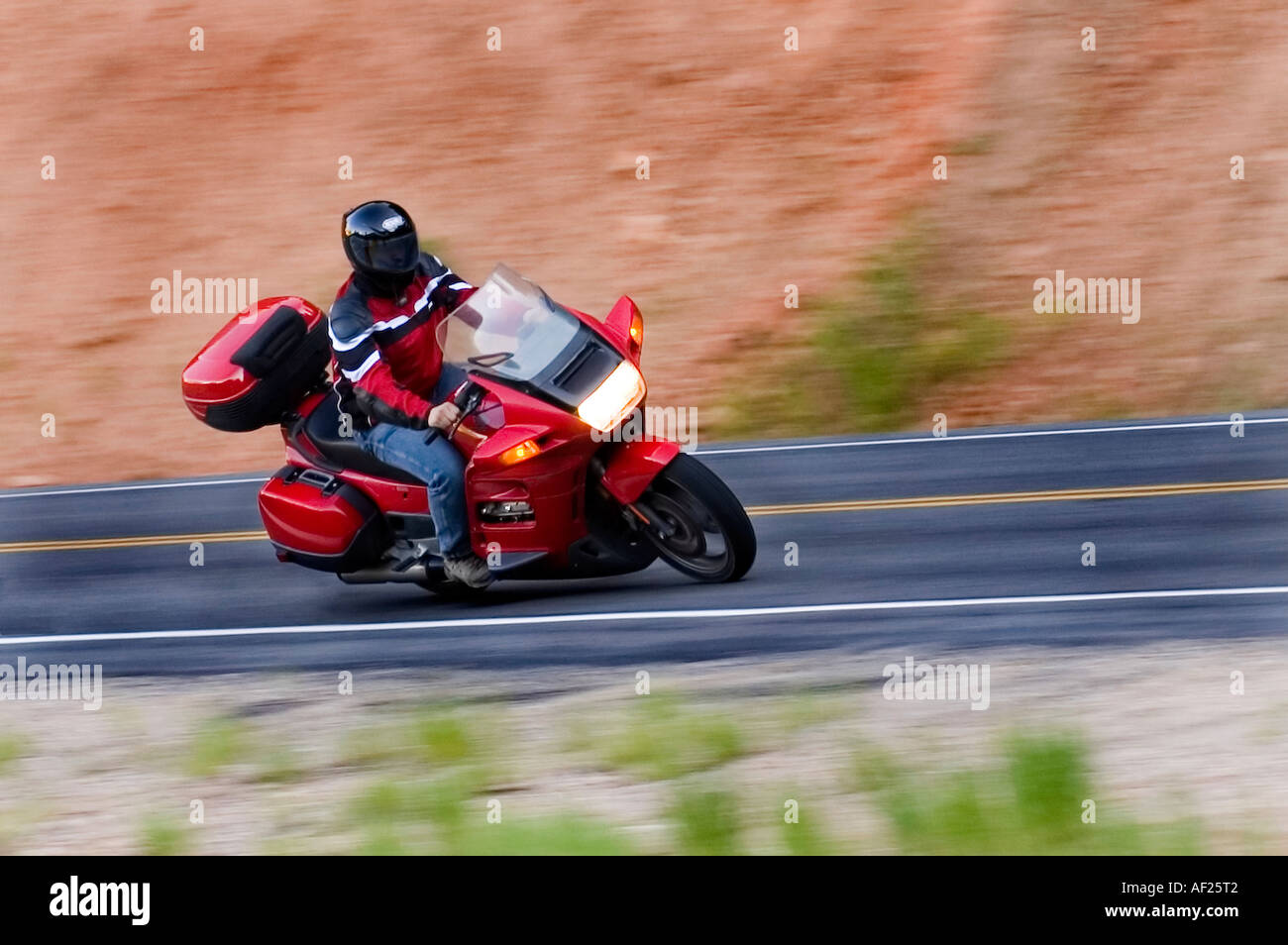 L'homme en blouson de cuir sur sa moto-coins dans ce coup avec beaucoup de flou de mouvement Banque D'Images