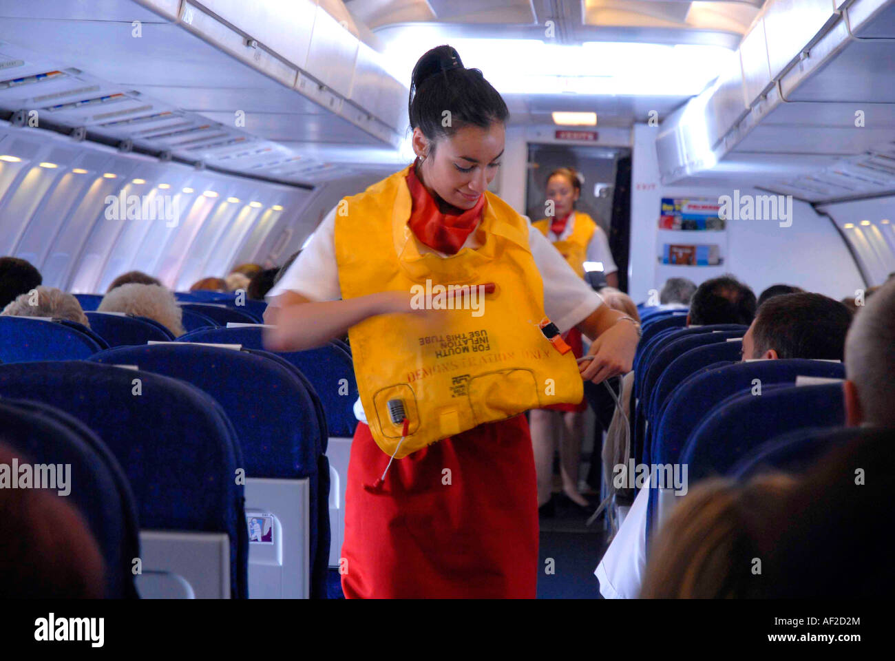L'équipage de cabine de jet passagers montrer comment mettre un gilet de sauvetage en cas d'urgence Banque D'Images