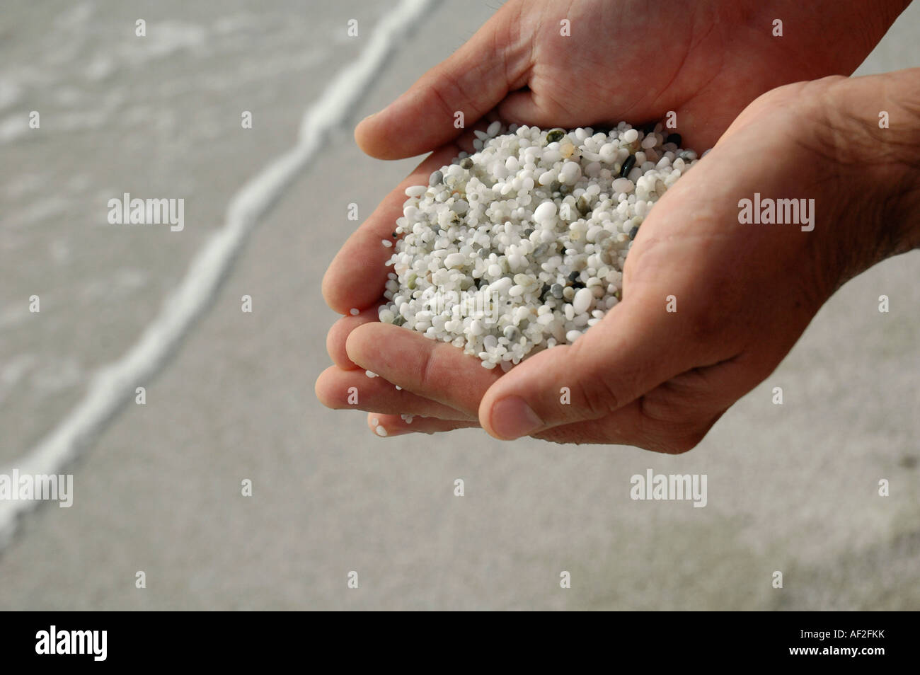 Man holding sand fait de grains de quartz dans les creux des mains Banque D'Images