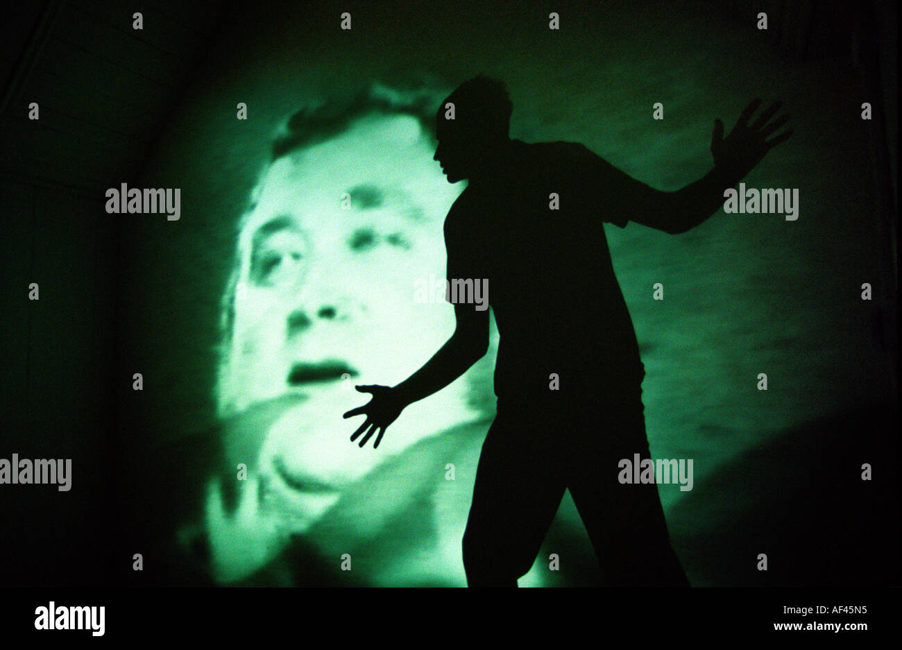 Une image de Bernard Manning, le comédien, projetées sur un écran avec une silhouette d'un élève dans l'avant-plan. Banque D'Images