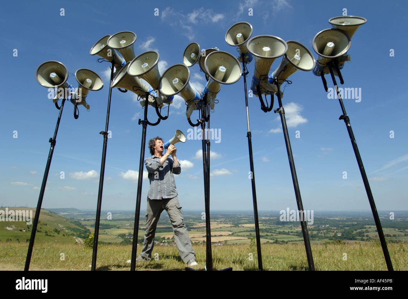 Compositeur et directeur de la chorale crier Orlando Gough avec mégaphones sur Devils Dyke, 'South Downs' 'National Park' Sussex UK Banque D'Images