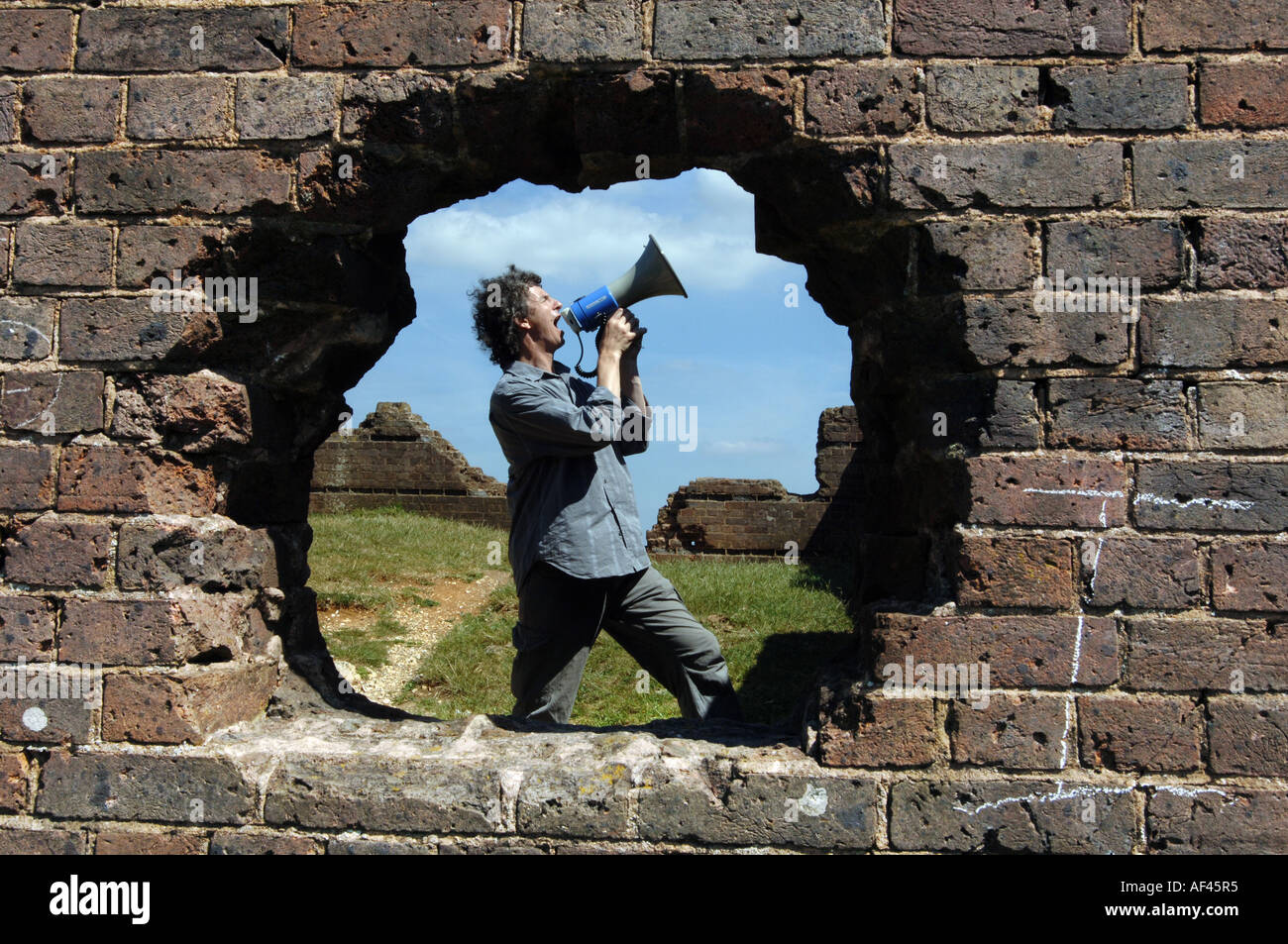 Compositeur et directeur de la chorale crier Orlando Gough avec mégaphone sur Devils Dyke, 'South Downs' 'National Park' Sussex UK Banque D'Images
