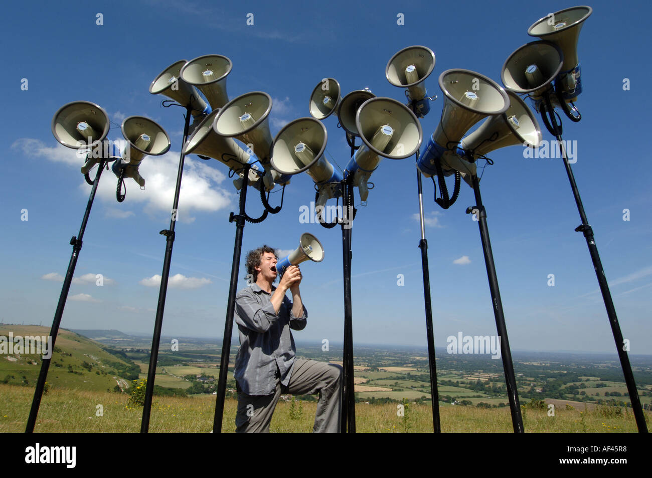 Compositeur et directeur de la chorale crier Orlando Gough avec mégaphones sur Devils Dyke, 'South Downs' 'National Park' Sussex UK Banque D'Images