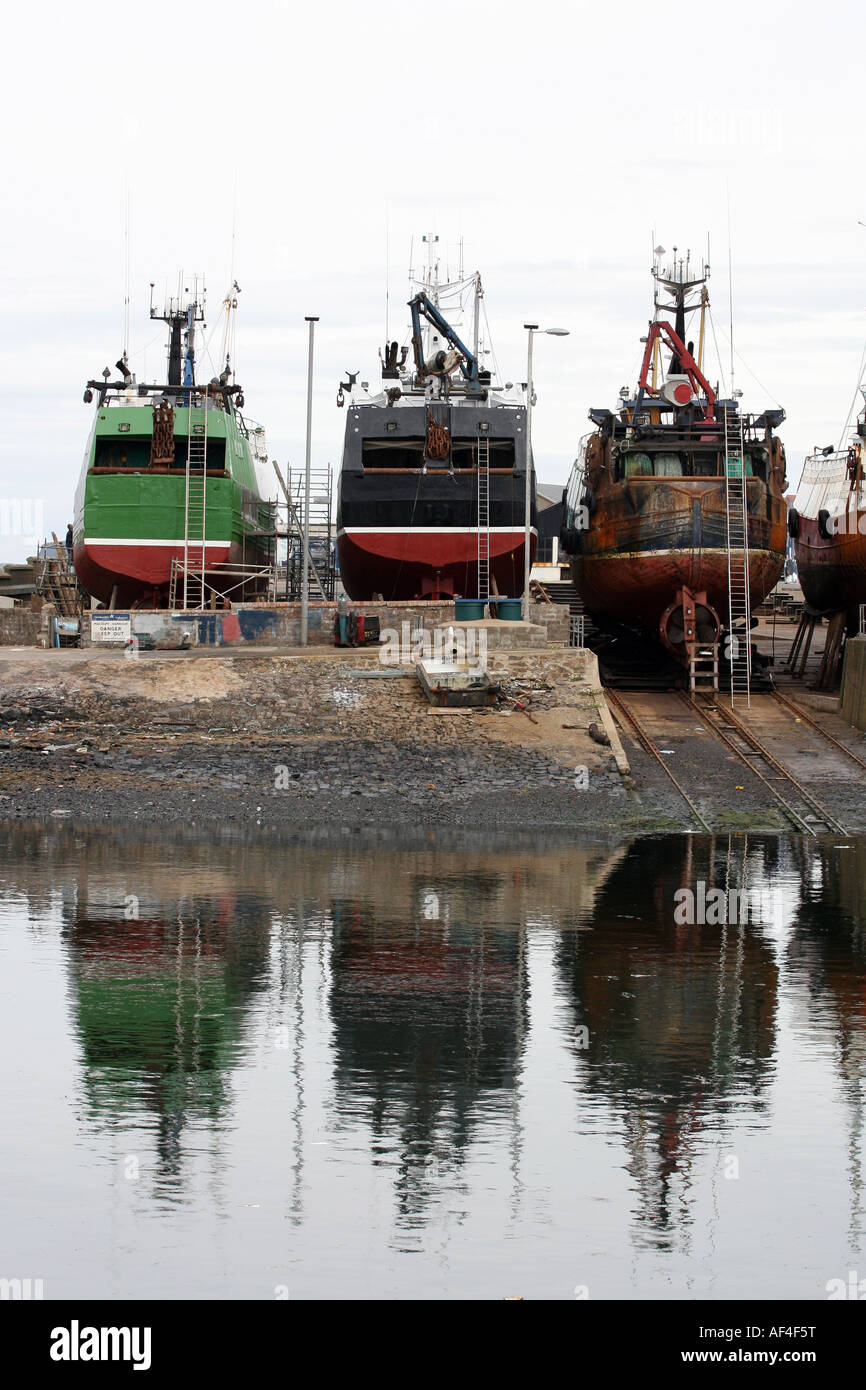 Bateaux de pêche en cours de réparation hors de l'eau au port de Macduff, Aberdeenshire, Scotland UK Banque D'Images
