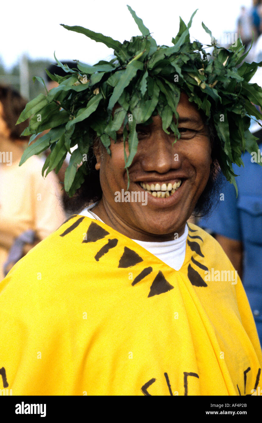 L'homme souriant en costume traditionnel tahitien portant poncho jaune vif et les jambières au Festival des arts du Pacifique Banque D'Images