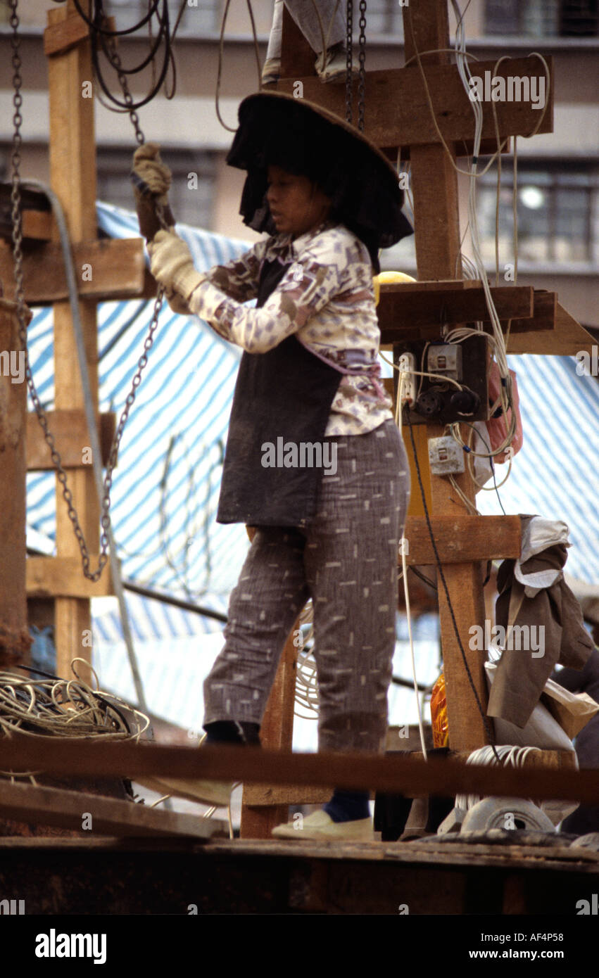 Une femme ronde large Hakka en chapeau noir avec frange pendaison  travaillant sur chantier, à la fin des années 70, Hong Kong Photo Stock -  Alamy