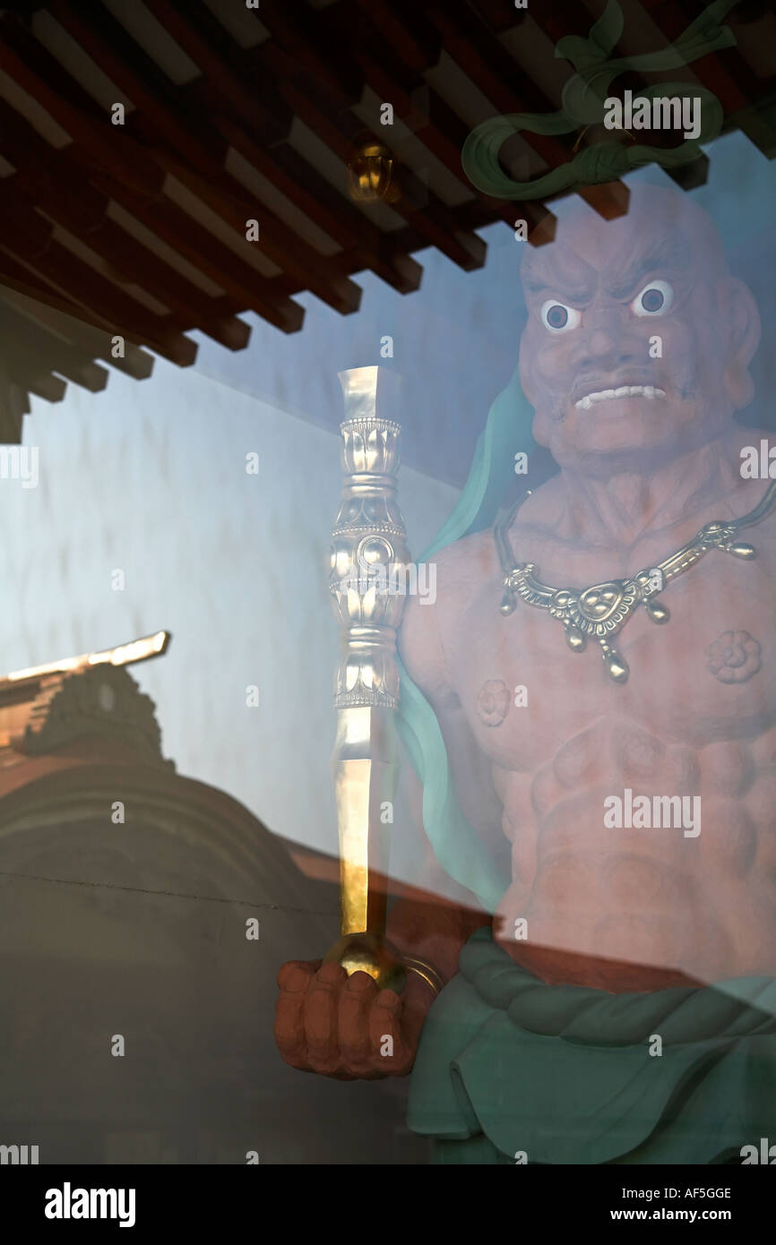 Deomo rouge statue vue à travers le verre avec culte réflexion osorezan shimokita aomori yeux composition forte feirce Banque D'Images