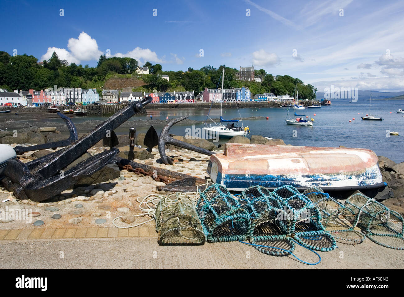 Maisons colorées le long de Tobermory Harbour avec old anchor en premier plan et les bateaux dans le port Ile de Mull Ecosse UK Banque D'Images