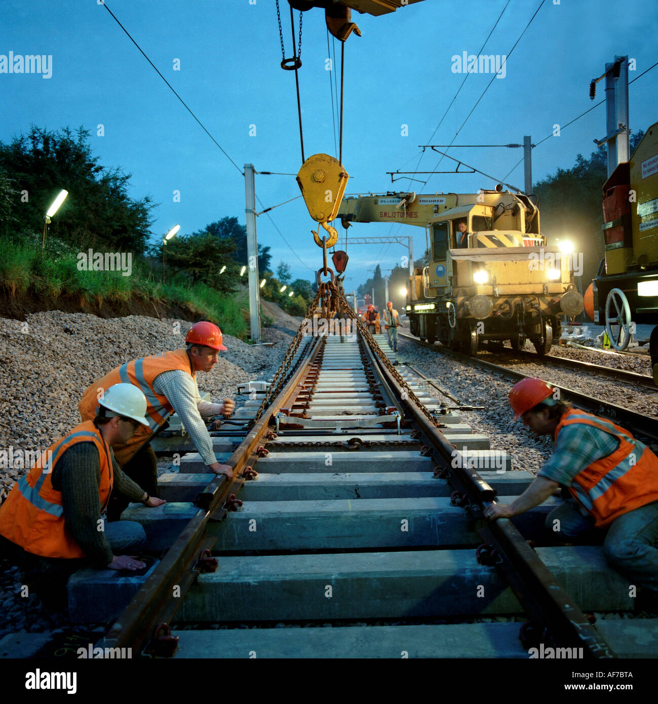 United Kingdom. L'Angleterre. Les hommes travaillant de nuit pose des rails de chemin de fer. Banque D'Images