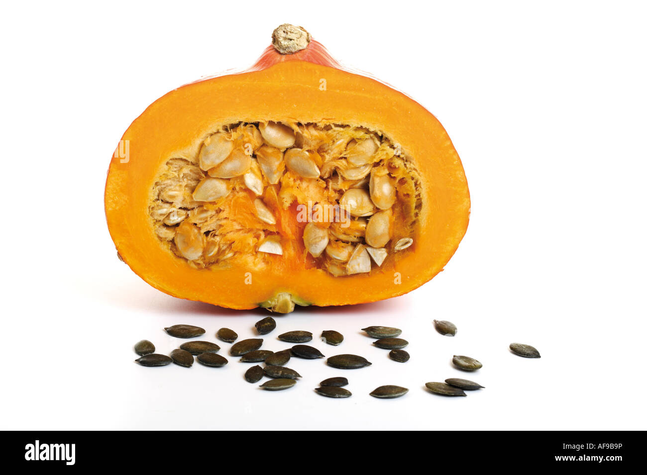 La moitié d'une citrouille, graines de citrouille devant Banque D'Images