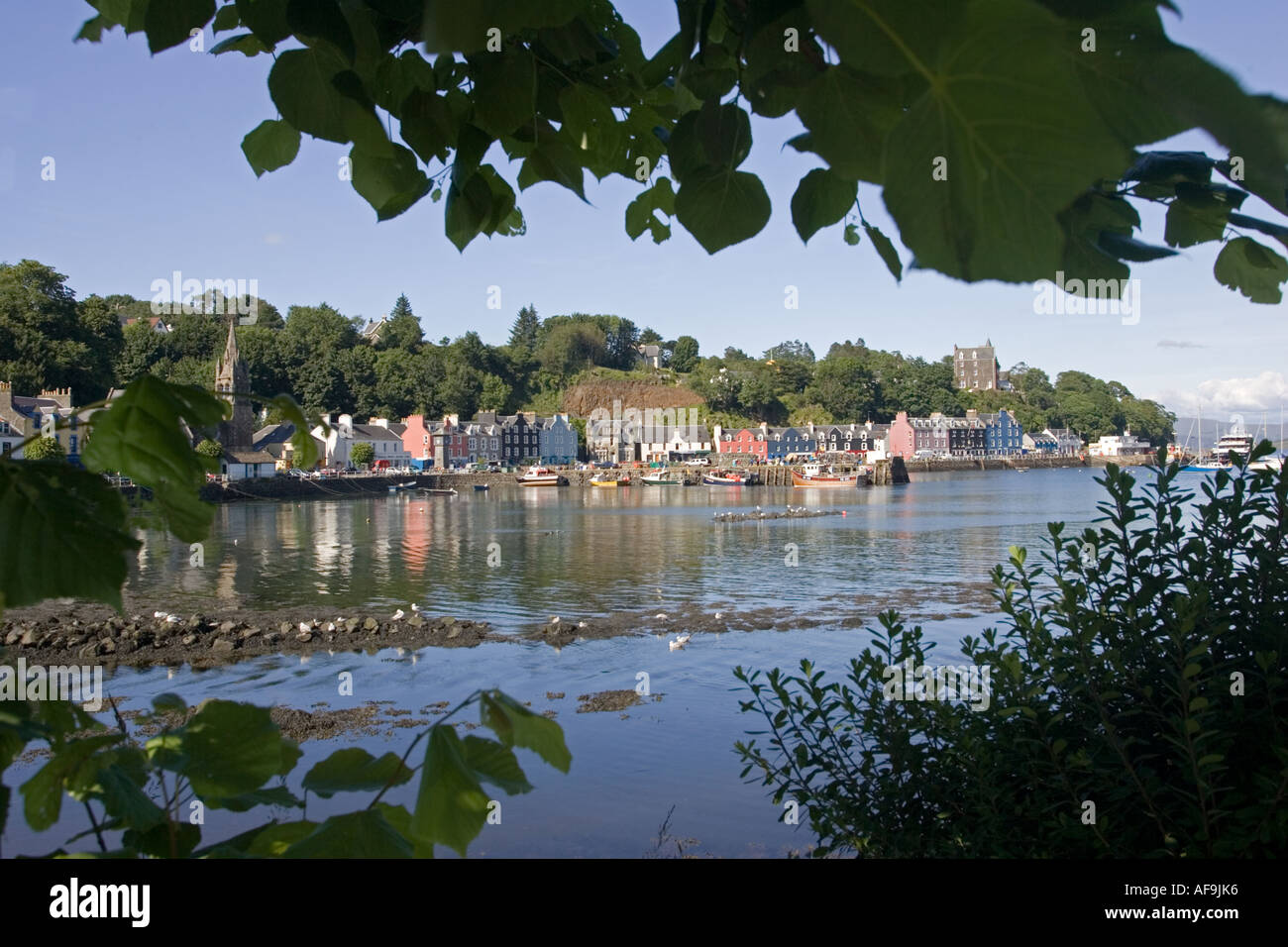 Maisons colorées le long de Tobermory Harbour avec old anchor en premier plan et les bateaux dans le port Ile de Mull Ecosse UK Banque D'Images