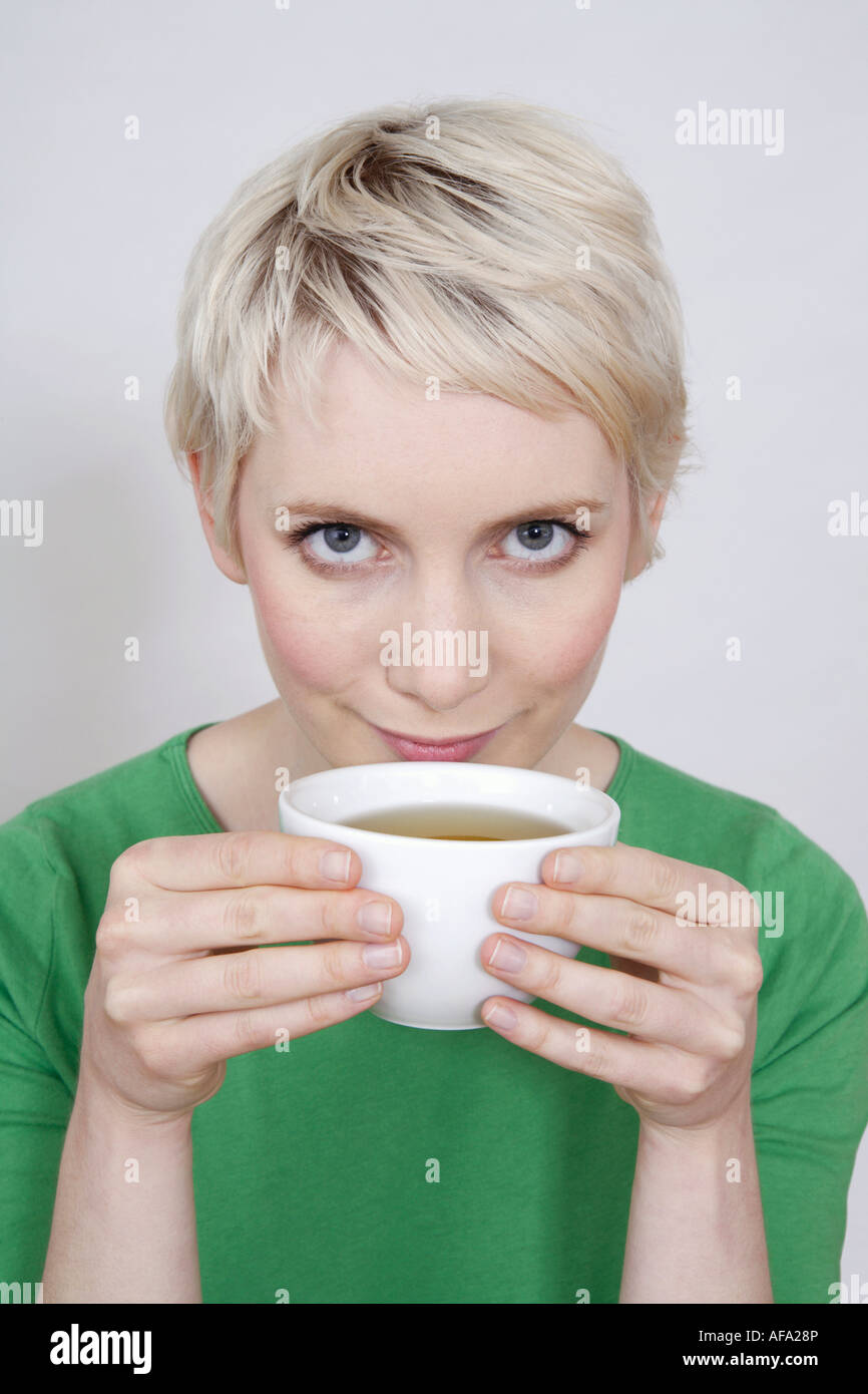Jeune femme tenant un bol de thé, portrait Banque D'Images