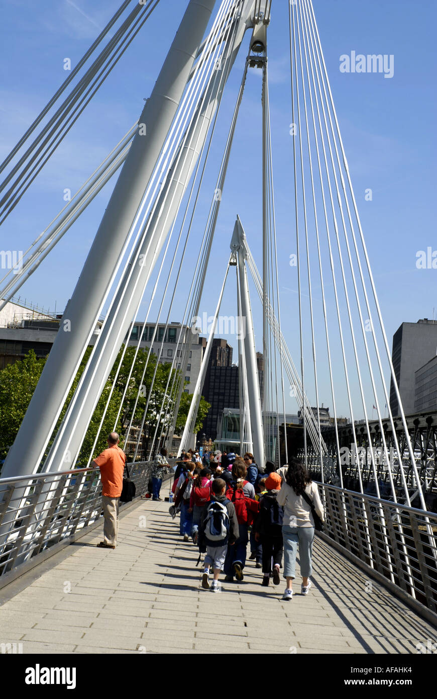 Les touristes marcher sur Hungerford Bridge vers la Southbank, salle des fêtes, traversant la Tamise. Londres, Angleterre, Royaume-Uni. Banque D'Images