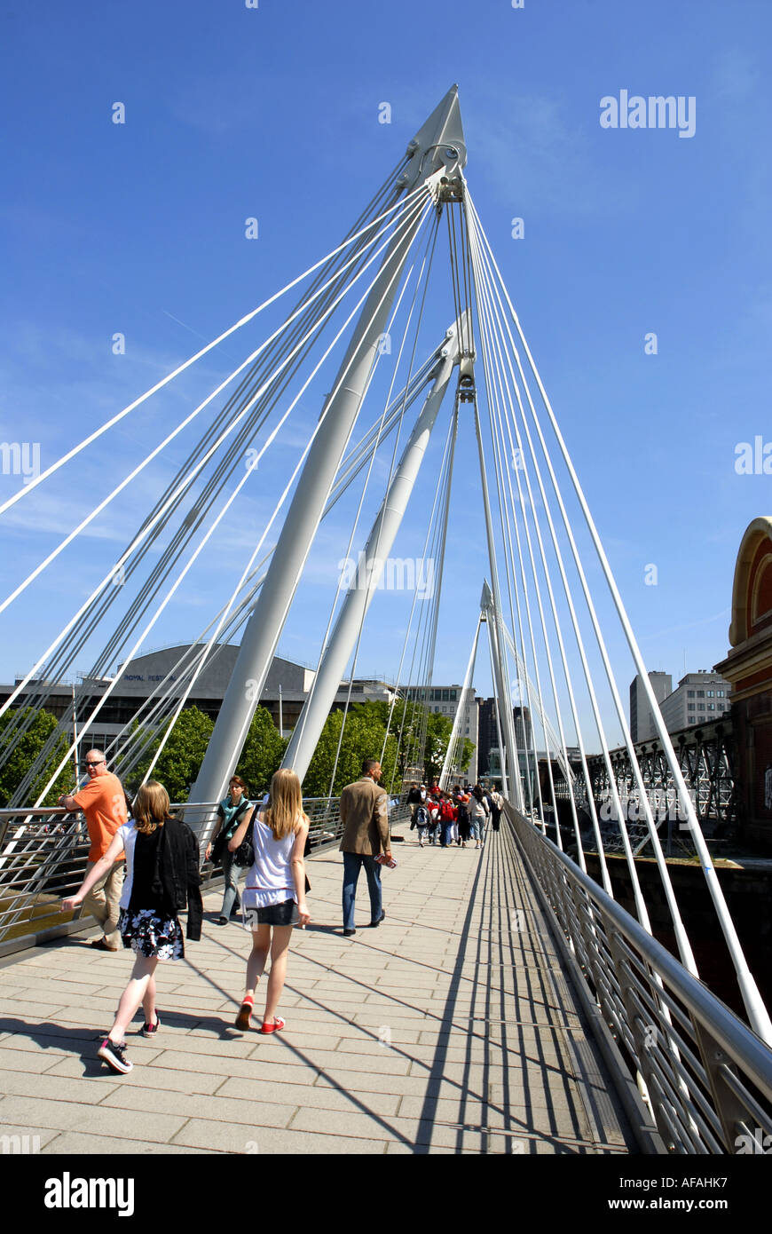 Les touristes marcher sur Hungerford Bridge vers la Southbank, salle des fêtes, traversant la Tamise. Londres, Angleterre, Royaume-Uni. Banque D'Images
