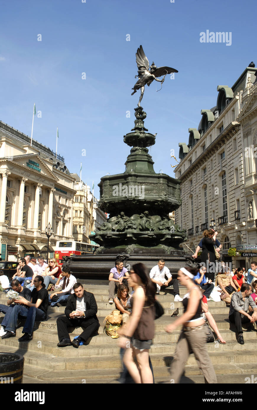 Les touristes assis sur les marches autour de la statue de bronze de l'Éros, Piccadilly Circus, Londres, Angleterre. Monument érigé en 1893 Banque D'Images