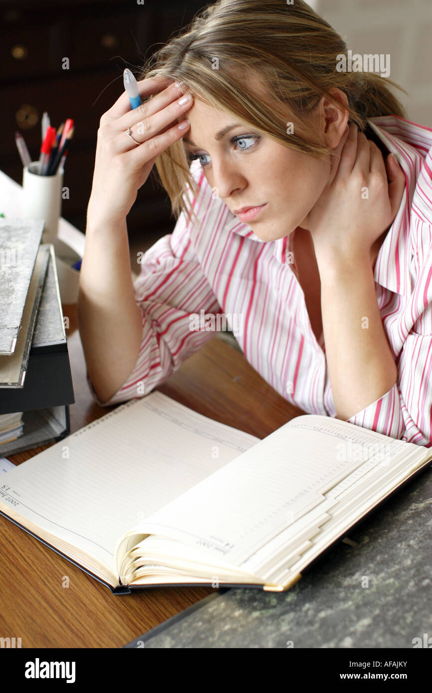 Jeune femme à la recherche a souligné dans le bureau Banque D'Images