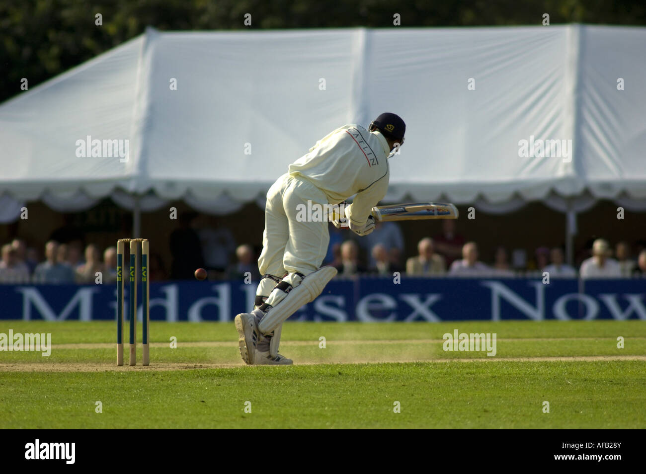 Joueur de cricket Middlesex playin leg oeil tourné avec poussière battant vers le haut. Banque D'Images