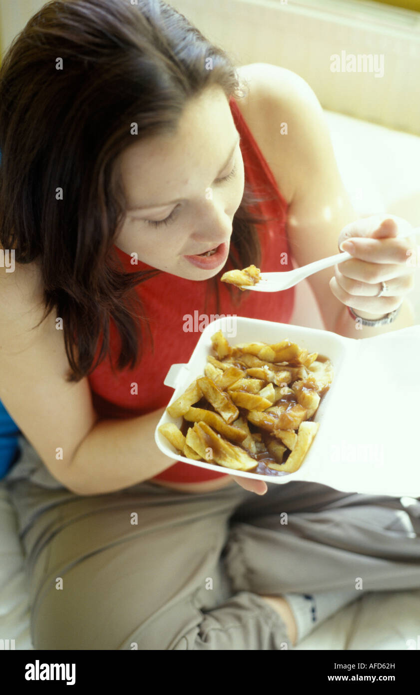 Woman eating chips Banque D'Images