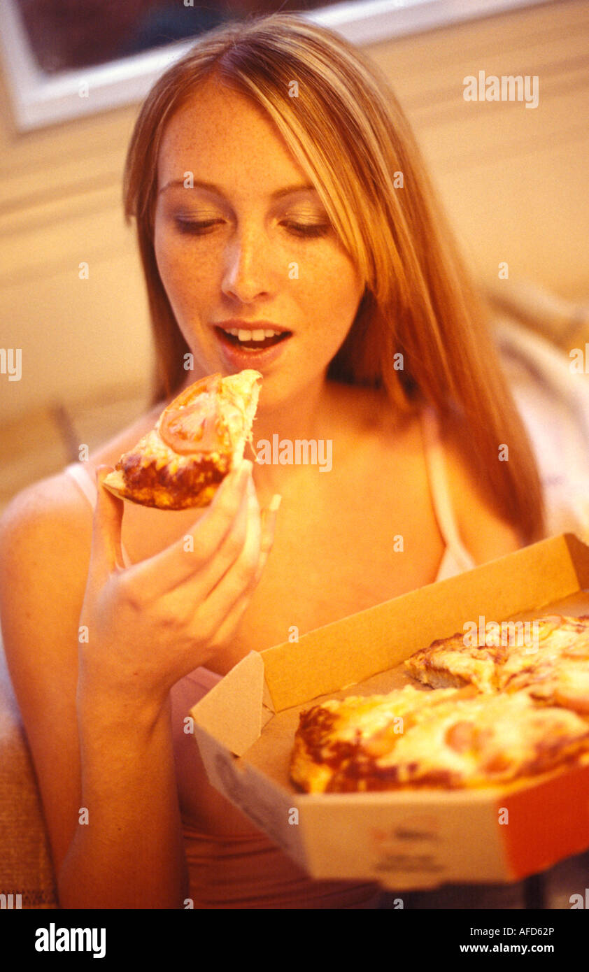 Woman eating pizza d'un fort Banque D'Images