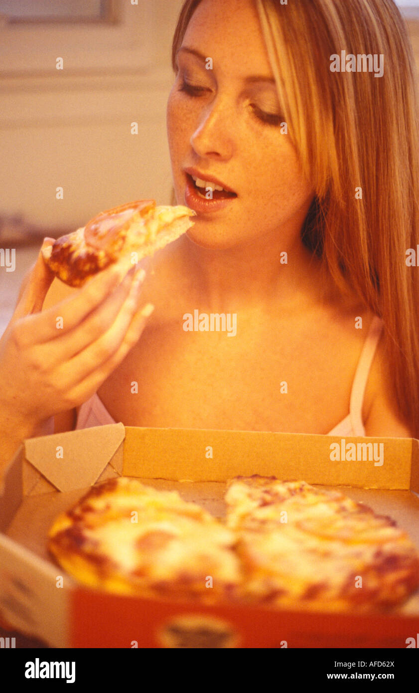 Woman eating pizza dans une boîte Banque D'Images