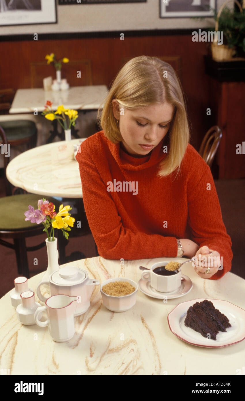 Femme à la mise en sucre moody son café Banque D'Images