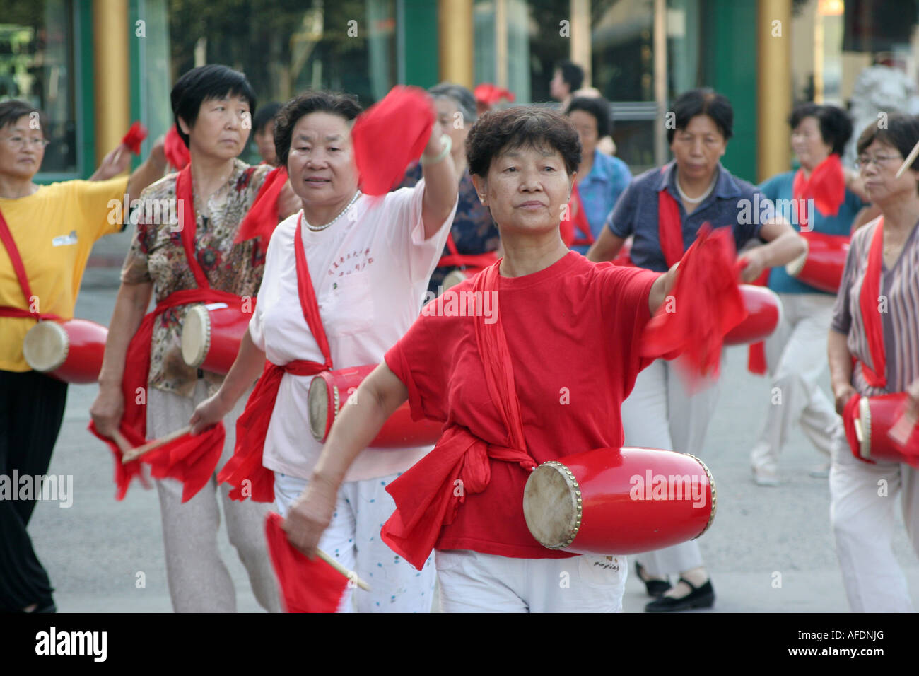 Les femmes avec batterie faire la gymnastique à l'extérieur tôt le matin de la ville de Yinchuan Ningxia Chine Août 2007 Banque D'Images