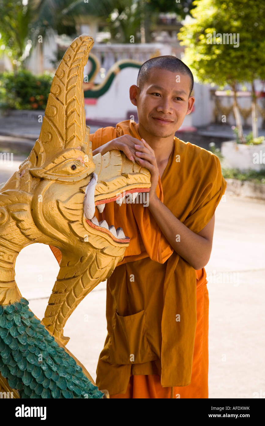 Moine novice avec tête de serpent décoratif Naga bannister à Wat Ong Teu Mahawihan, Vientiane, Laos Banque D'Images