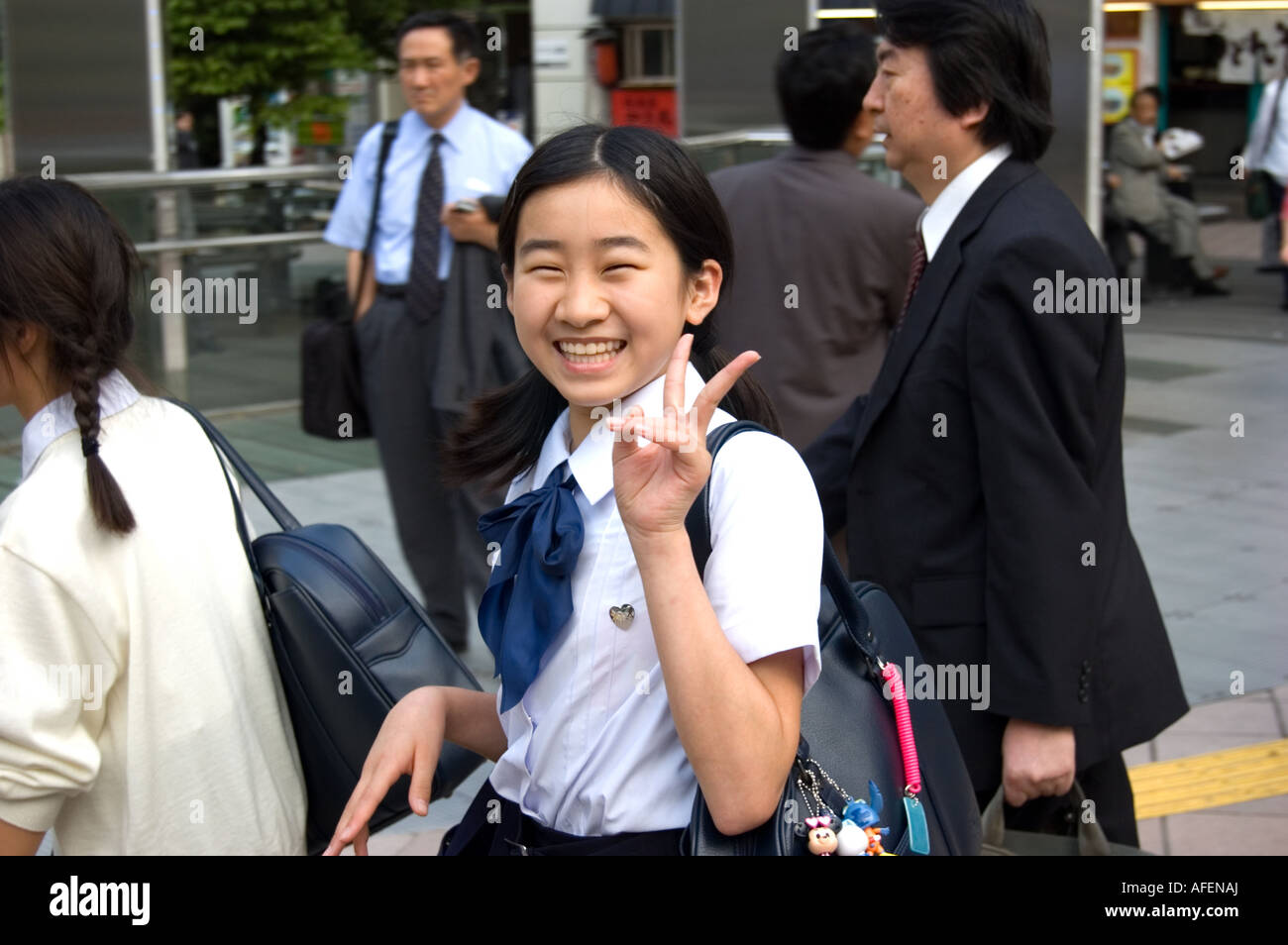 Japanese school girl clignote le signe de la paix Tokyo Japon Banque D'Images