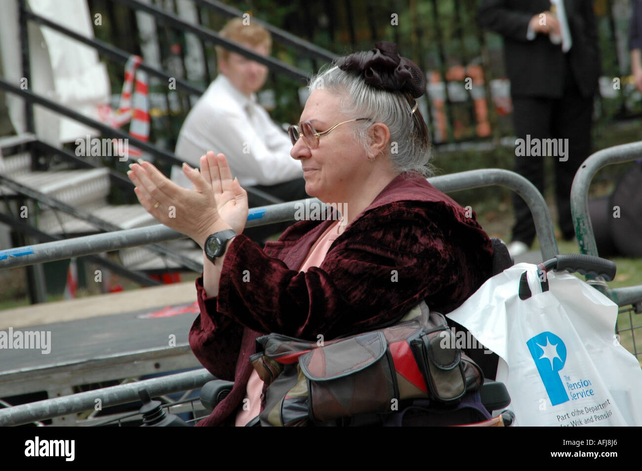 Femme sur un fauteuil roulant des mains à un show qui a eu lieu à Southwark, Londres, capitale Age Festival 2004 Banque D'Images